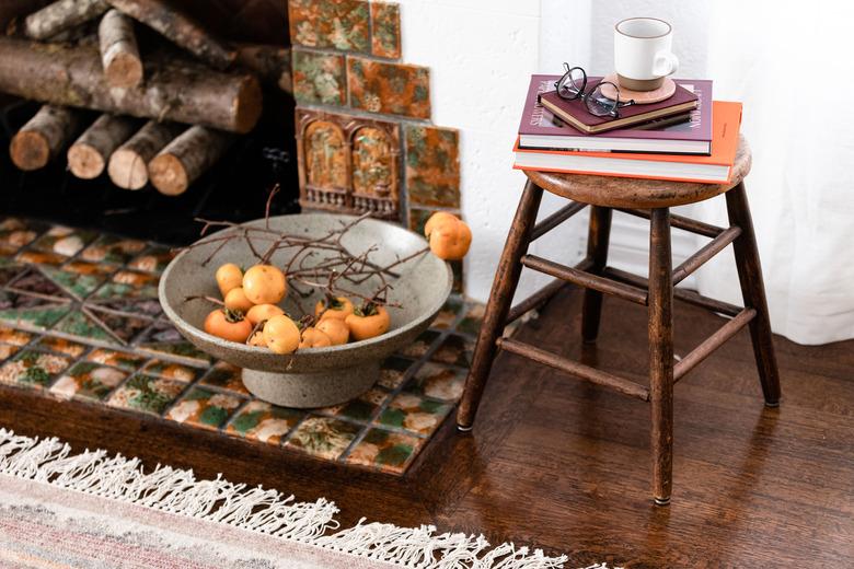 Fireplace and fireplace tile with stone bowl and wood stool