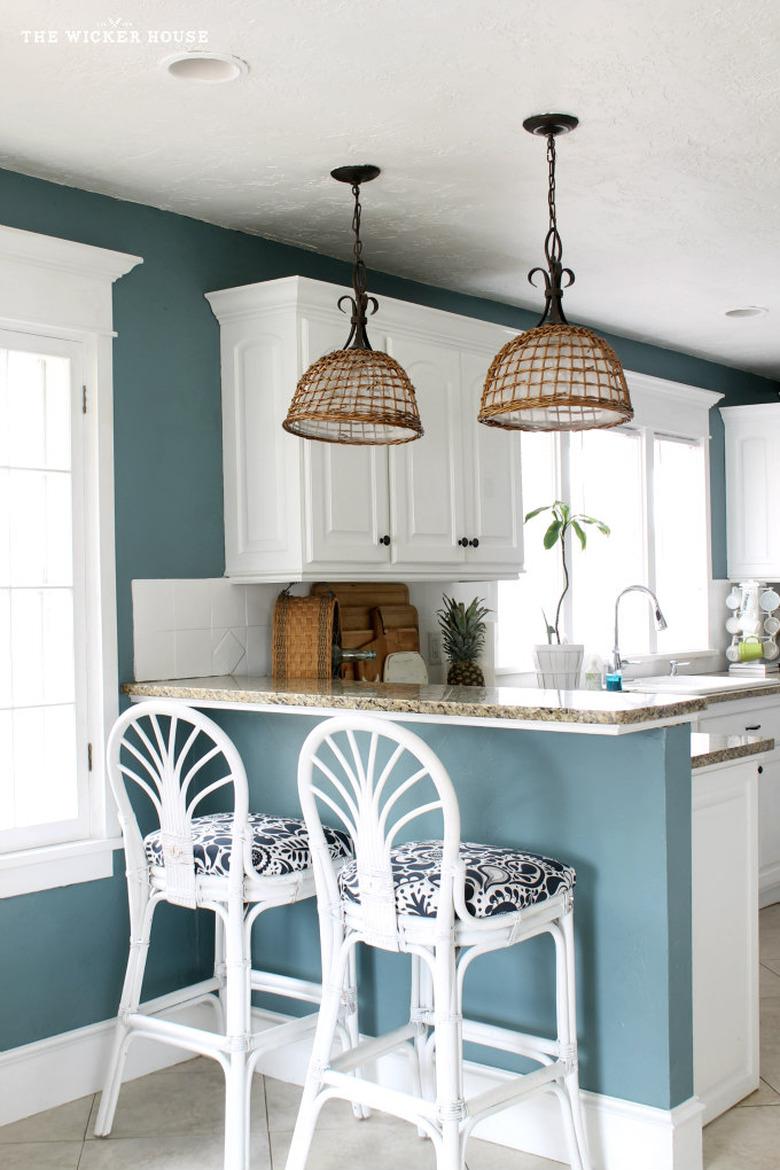 Coastal paint colors in kitchen with white wicker bar stools and teal walls