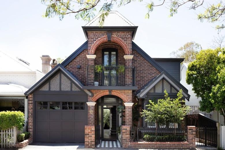 Brown brick house with black trim and garage door