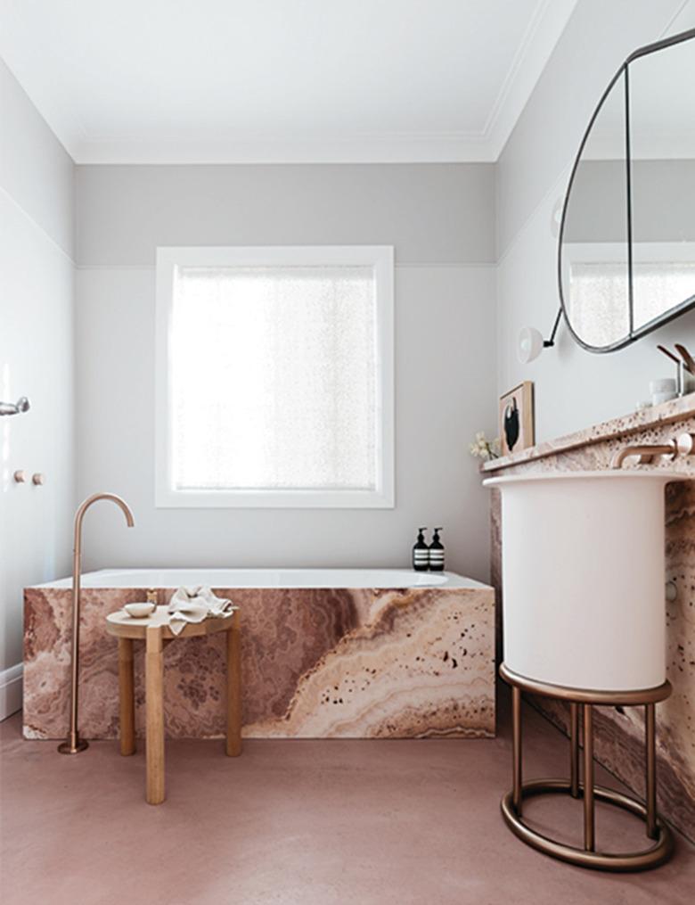 contemporary bathroom with rosy marble bathtub surround