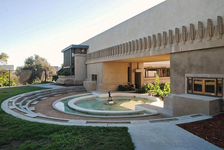 A large concrete house with a central circular fountain.