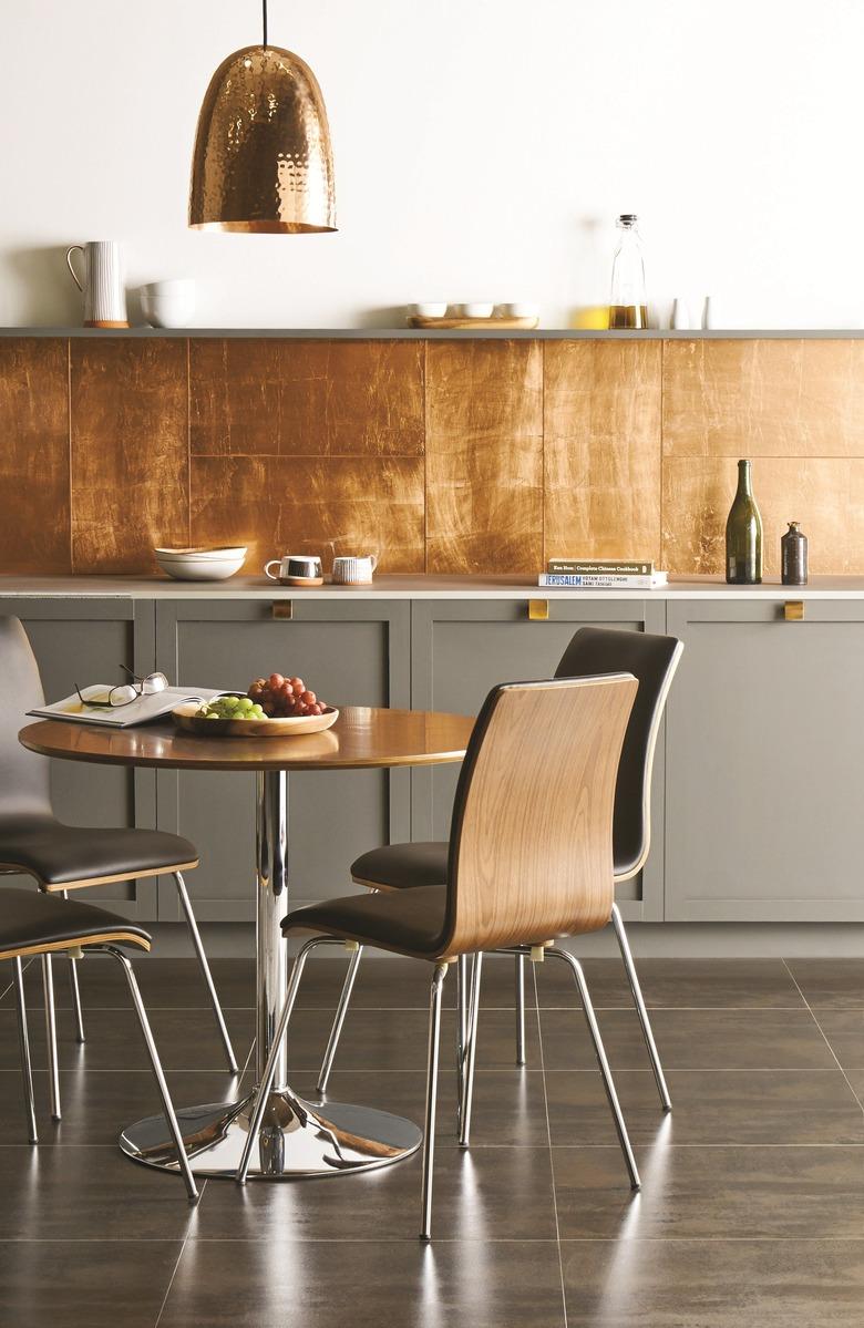 gray kitchen with copper backsplash and bell-shaped pendant light