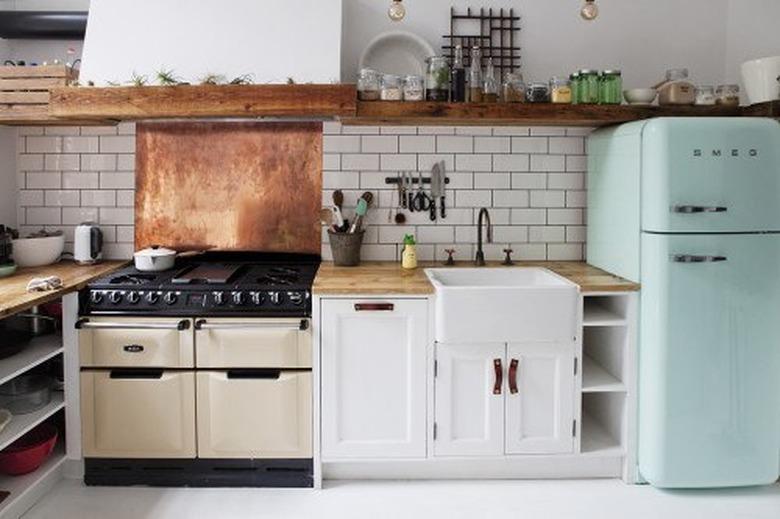 white industrial kitchen with copper backsplash