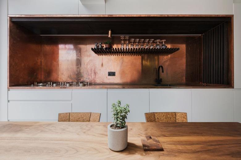 white and walnut kitchen with entire copper backsplash