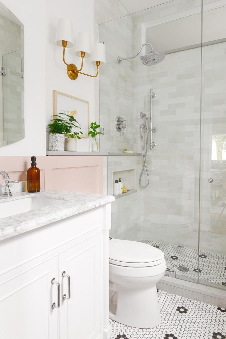 Corner shower with clear glass and marble tile walls