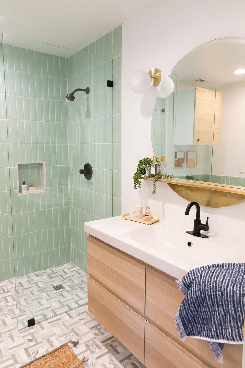 Corner shower with mint green tile and geometric floor tile