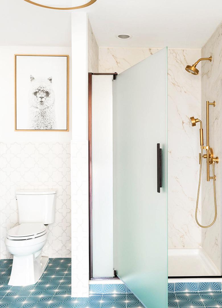 Corner shower with glass door and marbled walls