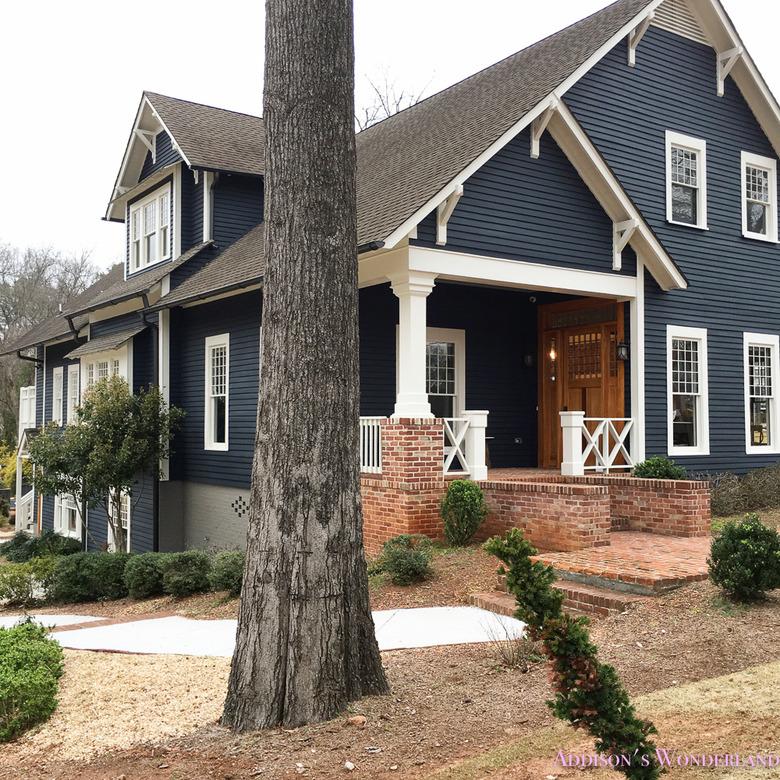 Dark navy blue Craftsman home exterior with white trim and warm wood front door