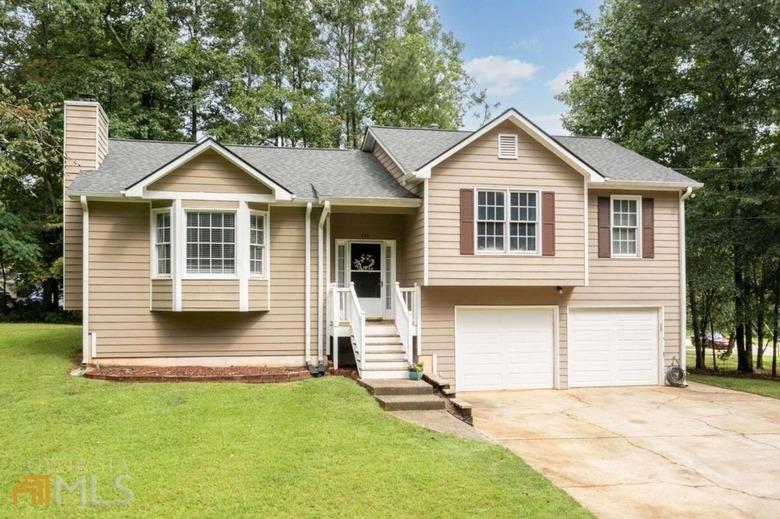 Light brown house with front yard and double garage