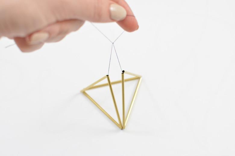 Geometric gold twig ornament with black thread