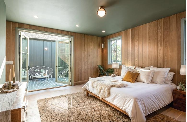 wooden paneled bedroom with green ceiling