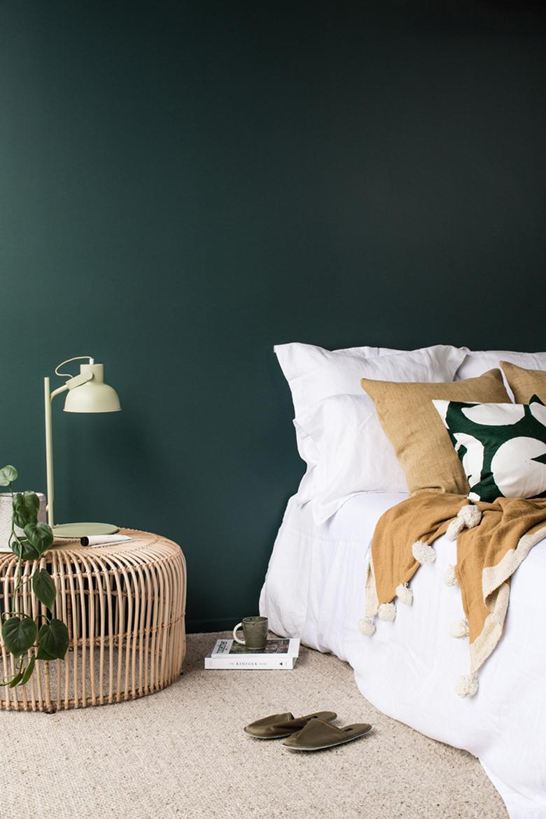 dark minimalist bedroom with rattan bedside table