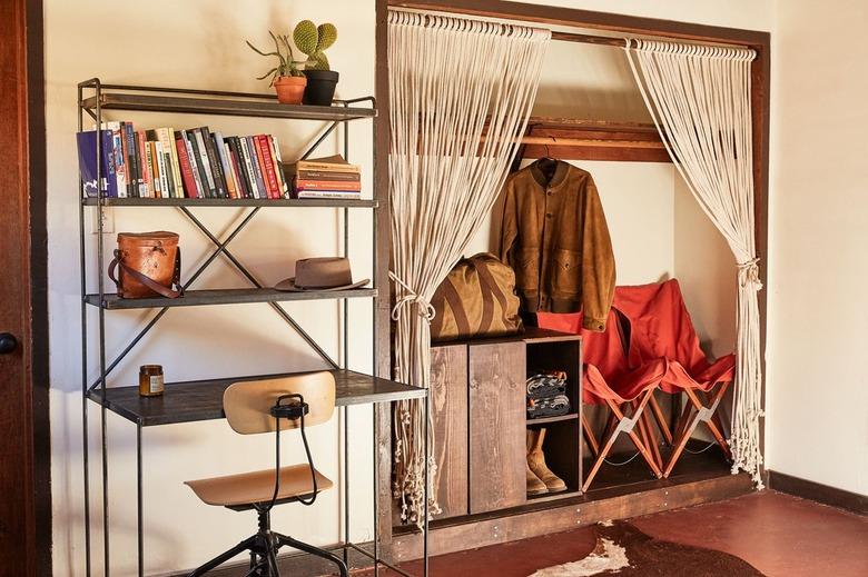 desert style home office with industrial desk and macrame closet curtains