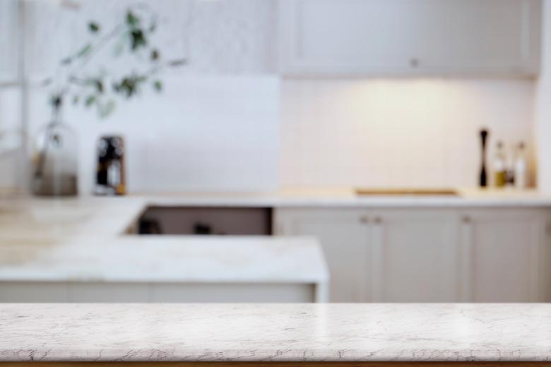 Empty white marble  table top and  kitchen background. for food and product display montage