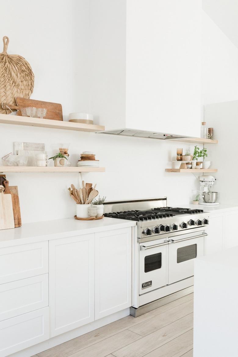 Large white kitchen with boho decor and professional range with double oven stove