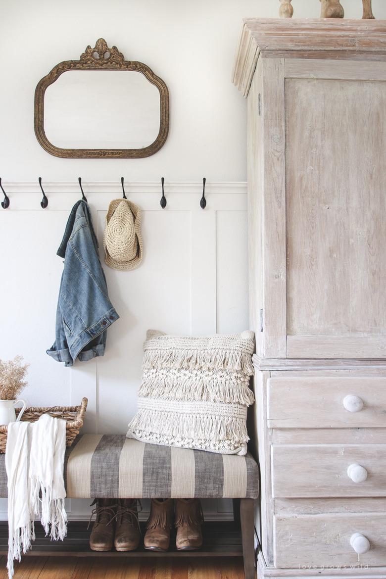 Entryway shoe storage underneath striped bench in farmhouse entryway