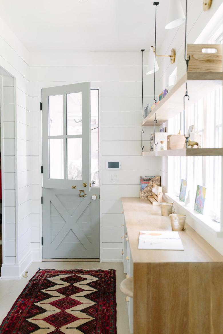 shelving with tchotchkes and Dutch style door with shiplap walls