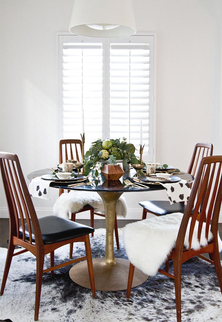 dining room with sheepskin throws on chairs and produce centerpiece