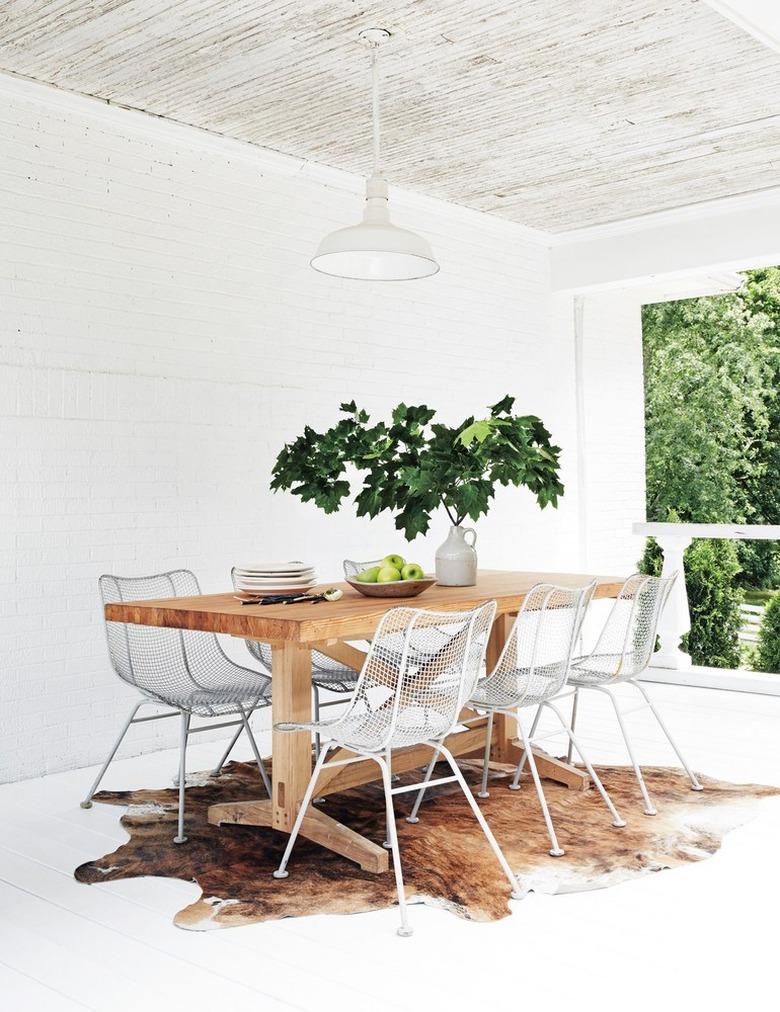 dining room with fresh foliage centerpiece and cowhide rug