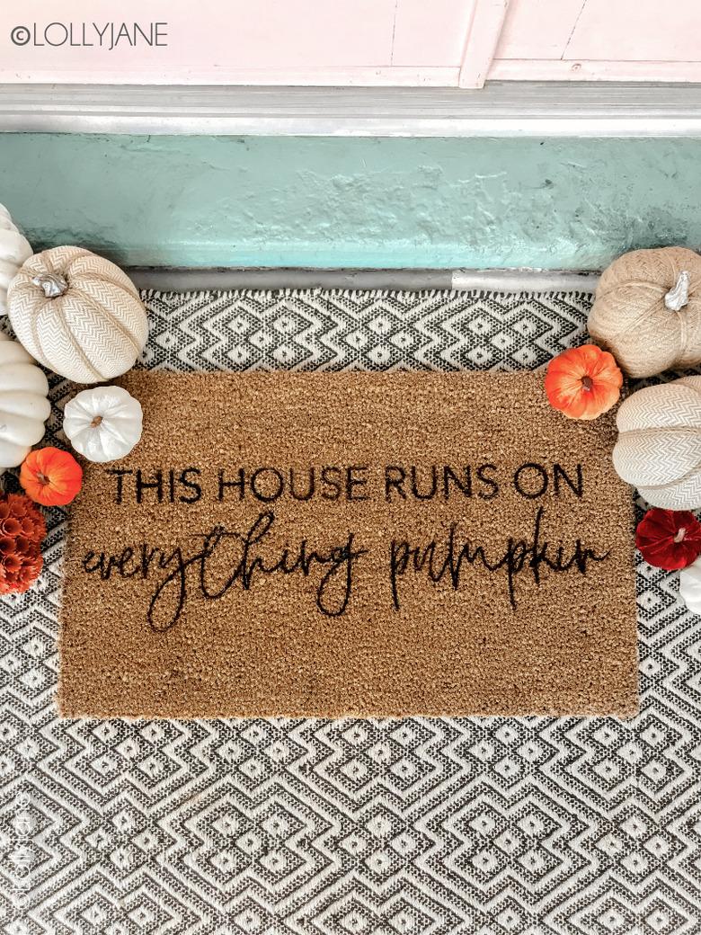 Stenciled fall doormat with patterned rug and pumpkins