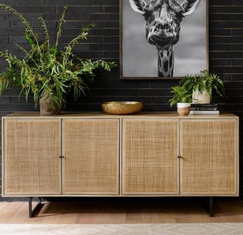 family room storage with beige cane credenza and plants