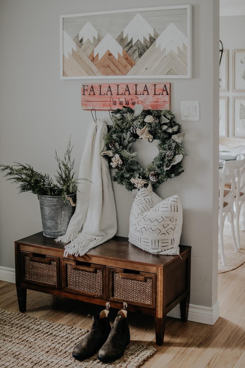 farmhouse Christmas decorating idea for entryway with Christmas wall art and winter greens