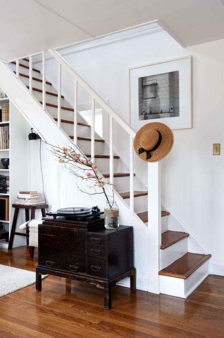 White staircase with wood flooring and farmhouse style furniture