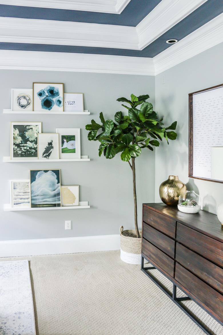 blue bedroom shelving idea with gallery wall and painted ceiling