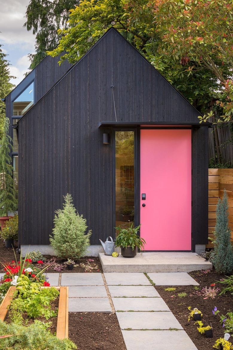 pink front door color on matte black house