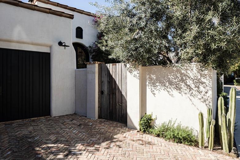 White Mediterranean style home with terra-cotta roofing and a wood door