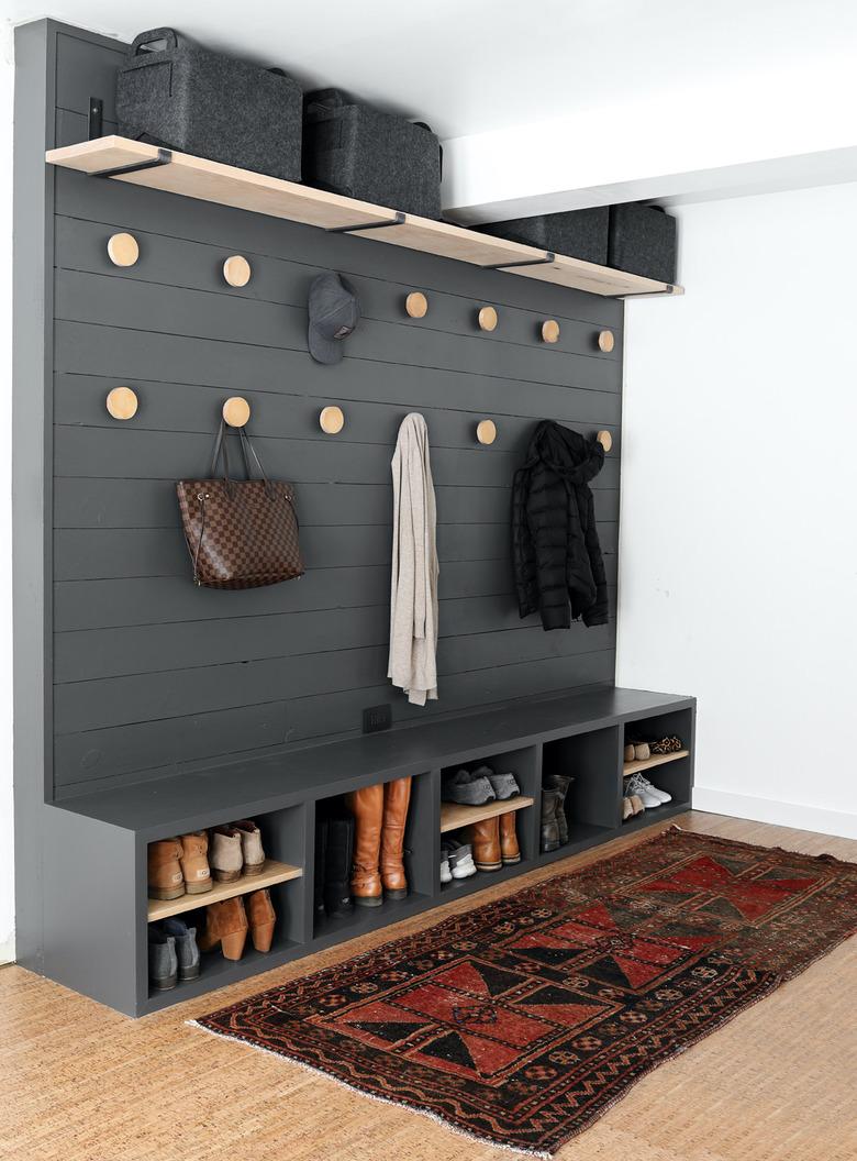 gray garage mudroom with built-in storage and handmade coat hooks