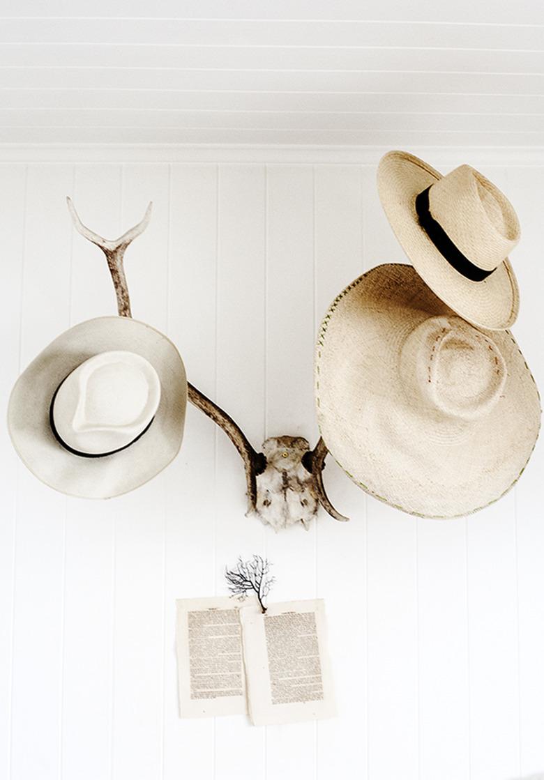 hats hung on faux antler taxidermy