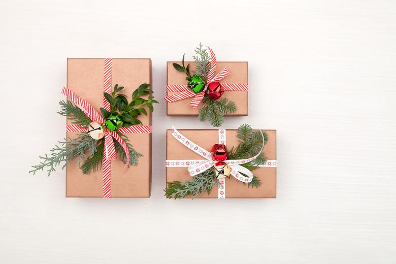 Christmas gift boxes decorated fir tree branches and bells on white background. Christmas, winter, New Year concept. Flat lay, top view, copy space