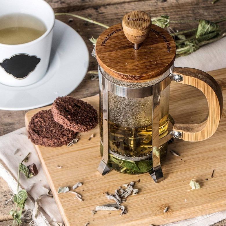 austero french press with tea on a cutting board.