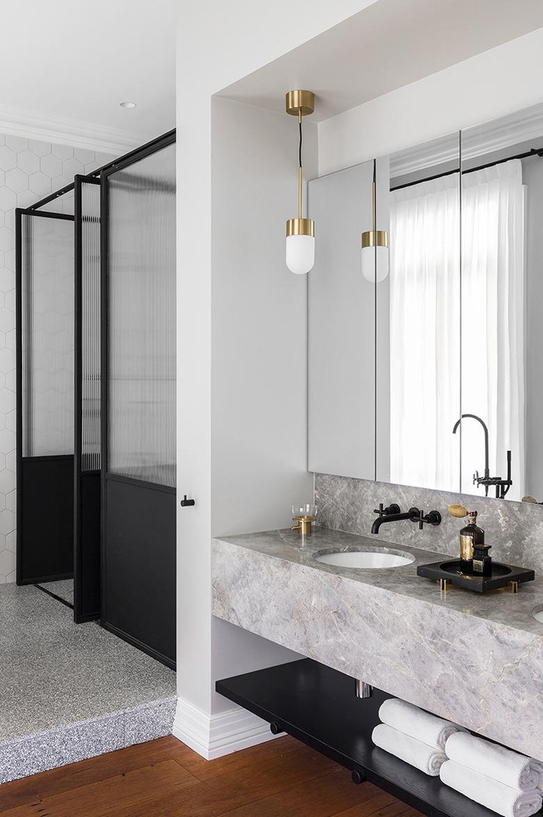 white modern bathroom with glass shower door and gray marble vanity