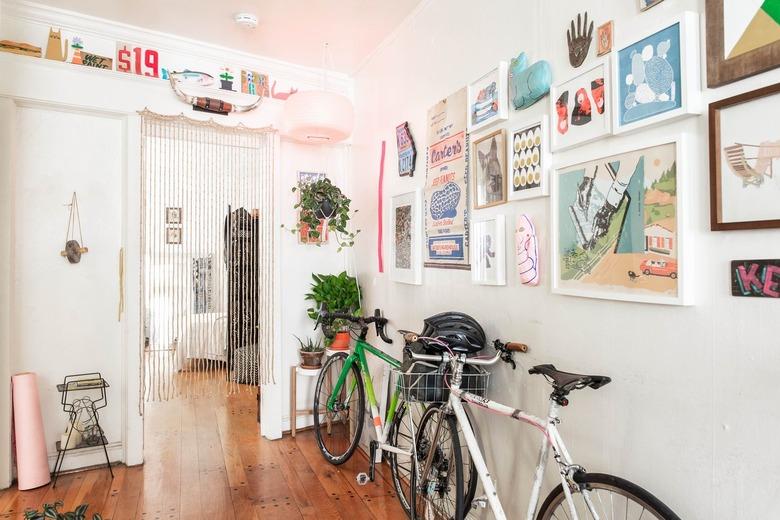 Apartment hallway with artwork and bikes leaning on them