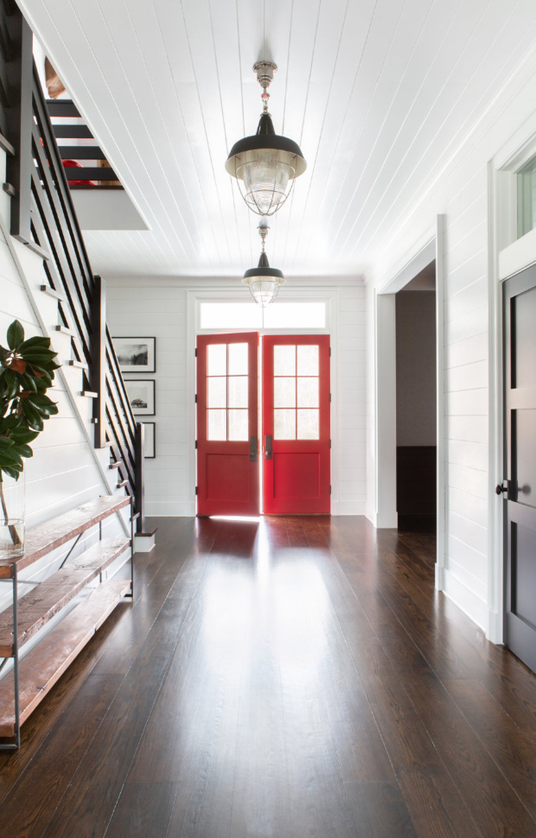 Hallway Pendant Light in Entryway with red doors, pendant lights, wood floors, stairs, credenza.