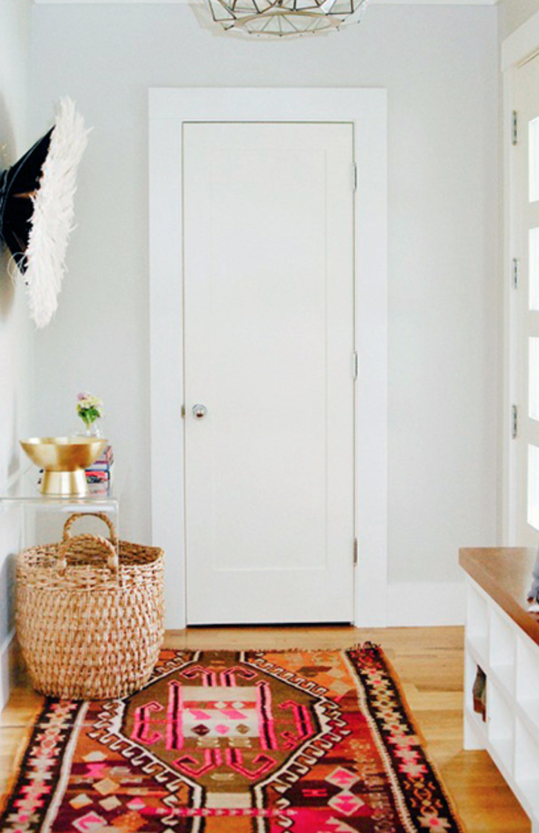 Hallway Runner Ideas in Entryway, basket, rug, wood floors, white walls, acrylic credenza.