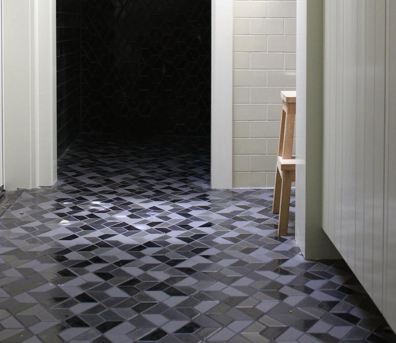 Multicolored geometric tile floor and white subway tile wall