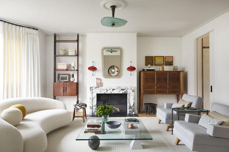 Living room with glass coffee table white couch and grey chairs