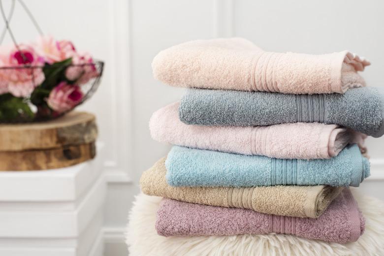 Stack of clean soft colorful towels. Flowers on background