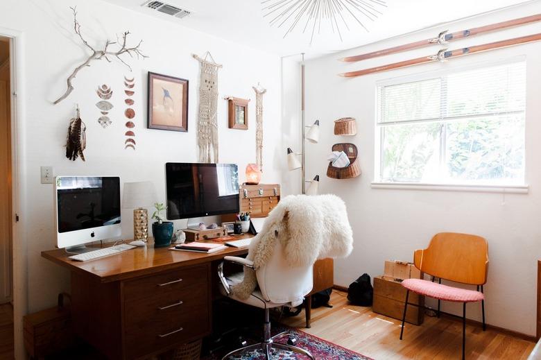 home office with large desk and wall hangings