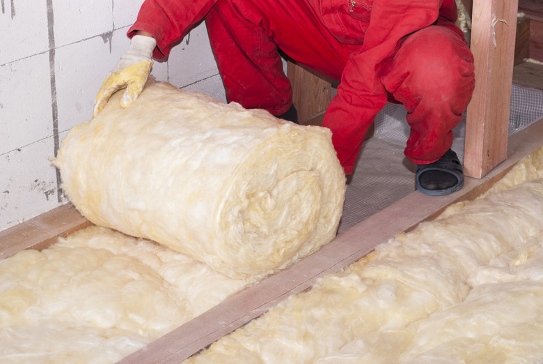 Fiberglass batt insulation being installed.