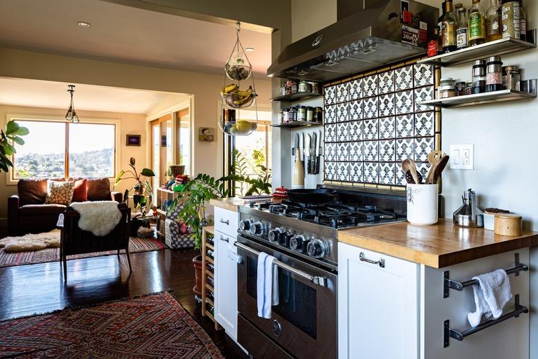 Eclectic kitchen with stainless range, tile backsplash and wood counters.