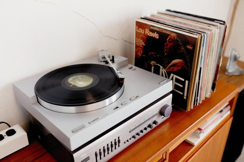 Wood credenza with a record collection and a record player. One record says, 'Lou Rawls Live!'