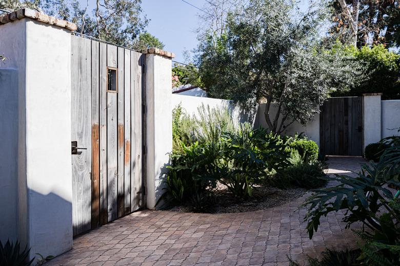 a decorative brick garden path in a Spanish-style home's backyard