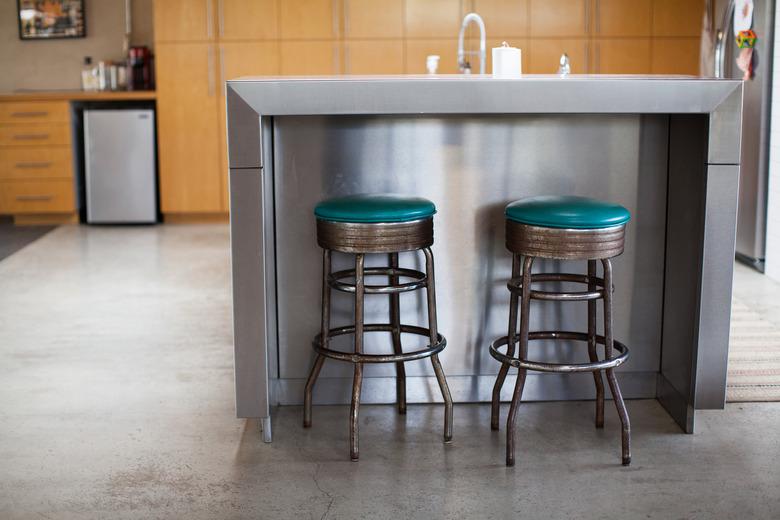 stainless steel kitchen island with two barstools