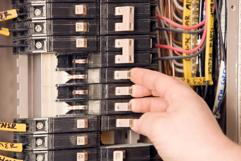 Electrician’s Hand Turning On Circuit Breakers