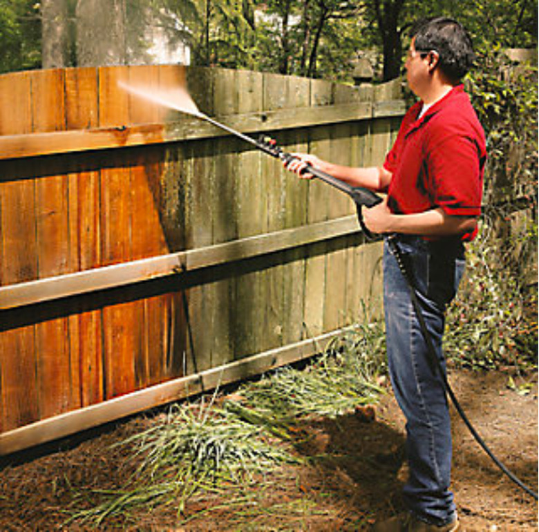 Pressure washing a fence.