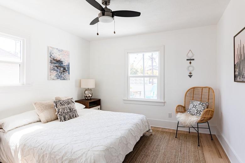 White bedroom with black ceiling light fan